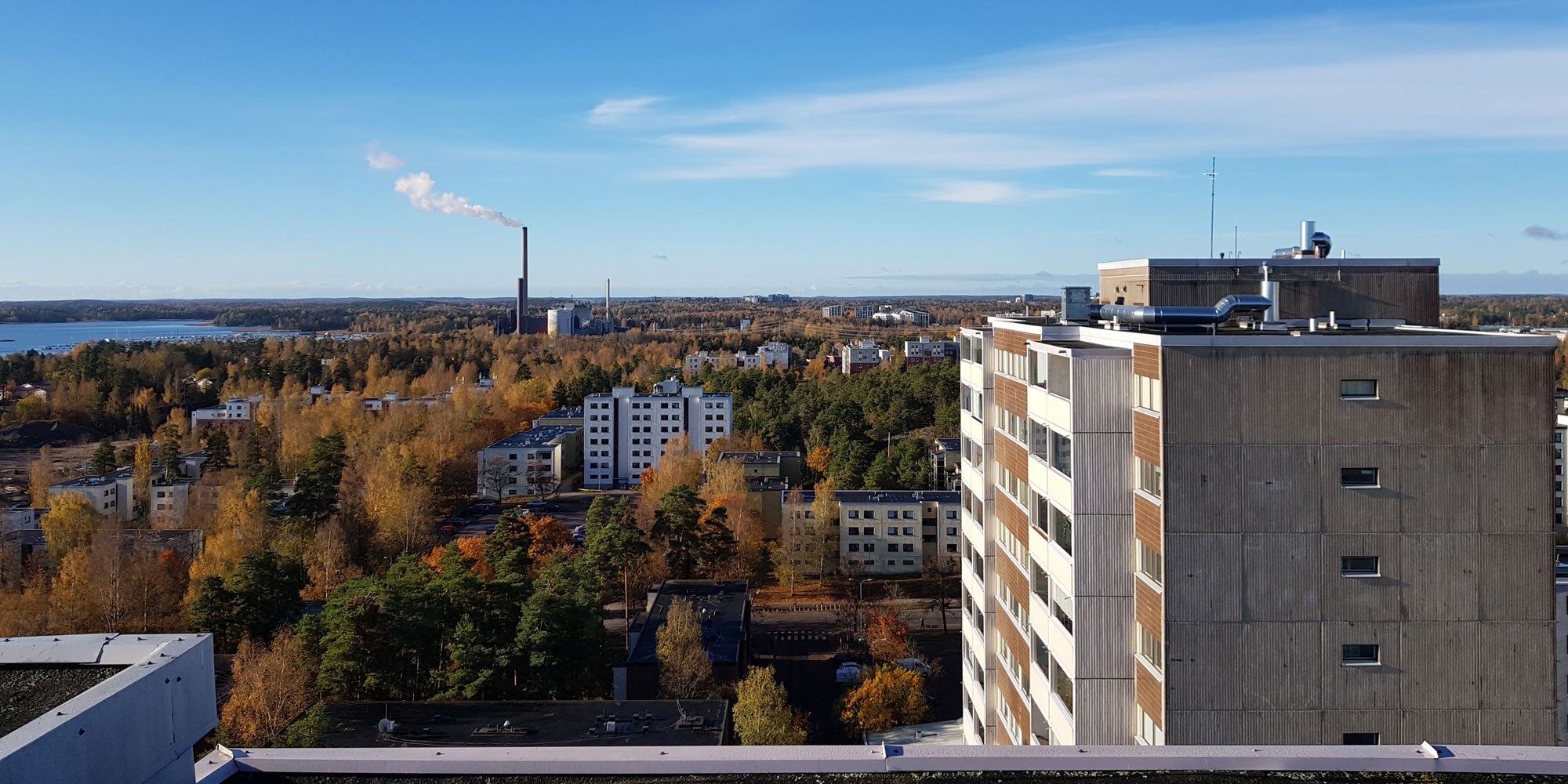 Kuva 16-kerroksisen talon katolta Matinkylässä kohti Matinkylän 1970-luvun asuinaluetta ja läntistä Espoota. Aurinkoinen ja tyyni syyspäivä.