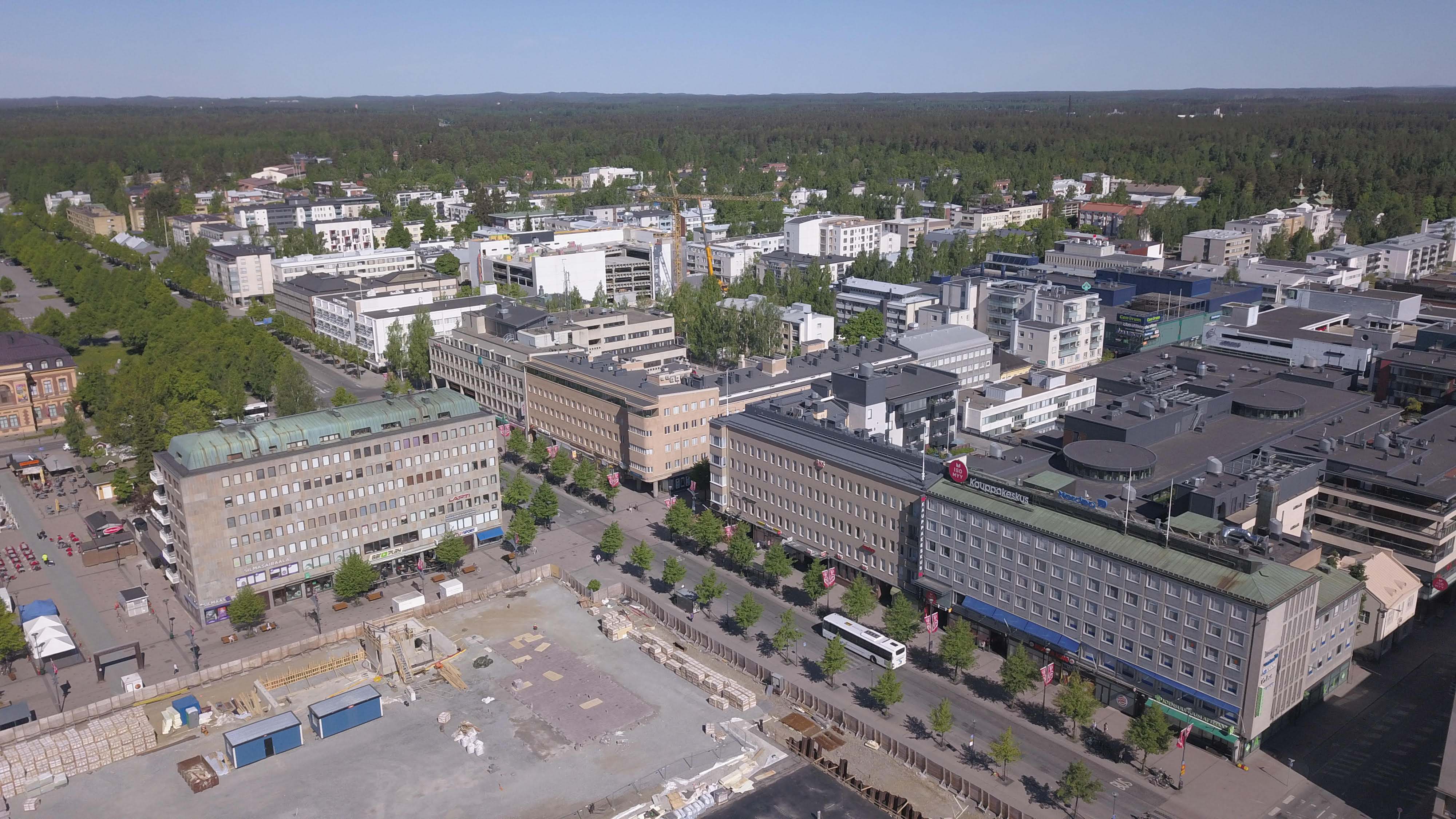 Joensuun liikekeskustaa, taustalla asuinkerrostaloaluetta. Ruutukaavakeskustassa rakentaminen on matalaa ja lehtipuuistutukset runsaita. Kuva: Maija Hakala.