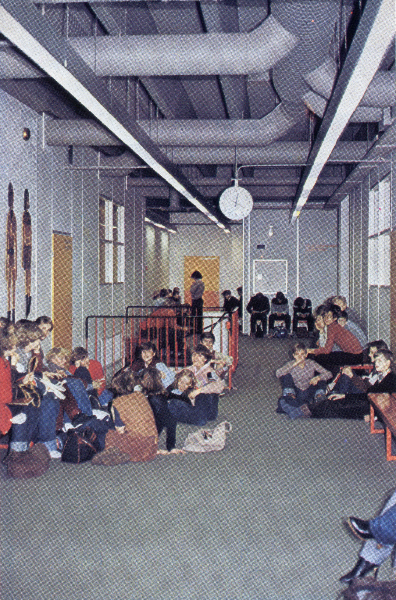 Koulun käytävillä on tilaa oleskella välitunneilla. Mattovalmistajien esite ”Kokolattiamatot ja terveys” 1980.
