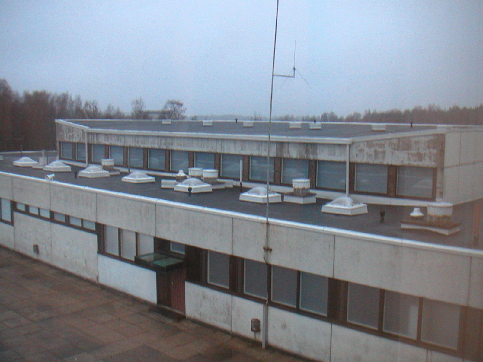 Rieskalähteen koulu, 1963, ulkokuva katolta. Rakennuksessa on loiva katto sisäpuolisella vedenpoistolla ja lukuisia kattoikkunoita.