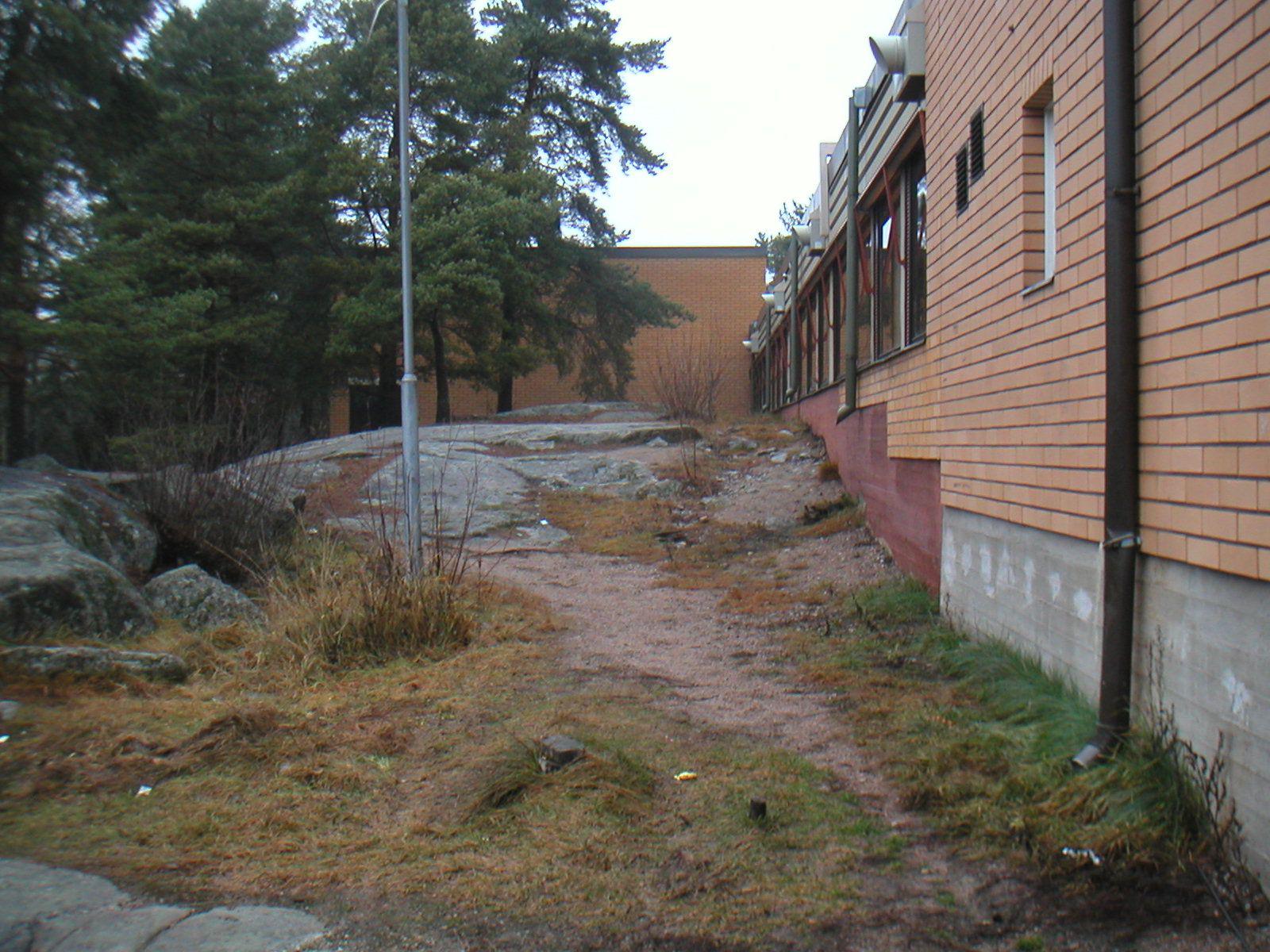 Uittamon koulu, 1972, ulkokuvassa maan alle jäävät rakenteet. 1970-luvun rakennusta varten oli tarpeen louhia kalliota. Ulkopuolisen kosteusrasituksen kuten sade- ja valumaveden huomioiminen kiinteistöä arvioitaessa on tärkeää.